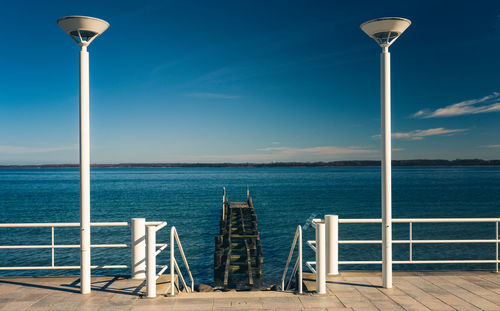 Street light on beach against sky