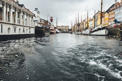 Boats in river with buildings in background