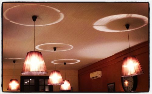 Low angle view of illuminated pendant light hanging from ceiling