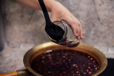 Close-up high angle view of hand pouring coffee in cup