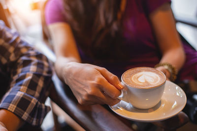 Midsection of woman holding coffee cup