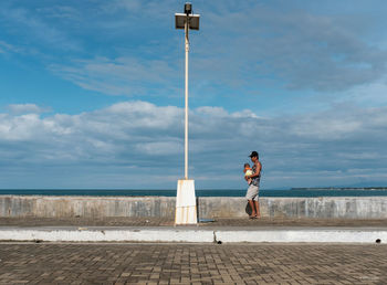 Man standing by sea against sky