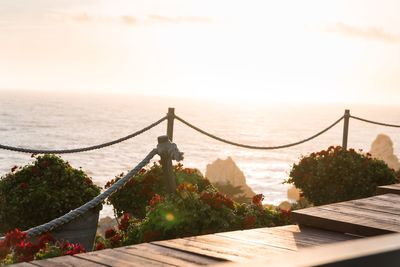 Bridge over sea against sky during sunset