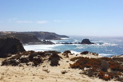 Scenic view of rocks on beach against sky