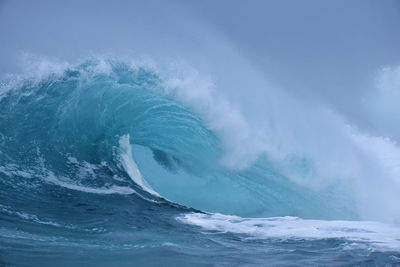 Sea waves splashing against blue sky