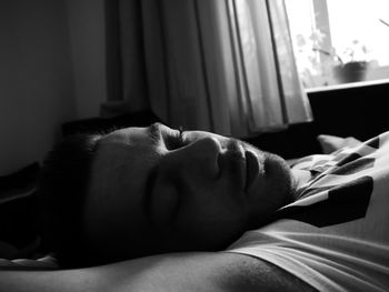 Close-up of man sleeping on bed at home