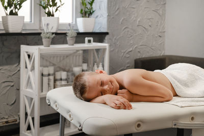 Child after back massage treatment in therapy clinic relaxing. kid body treatment