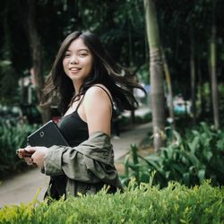 Young woman smiling while standing on grass