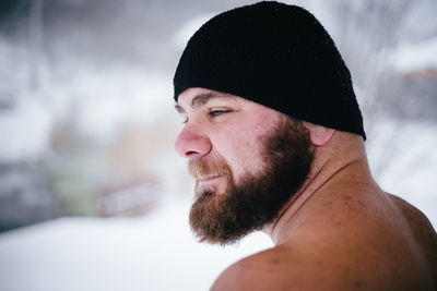 Close-up of bearded man on field during snowfall