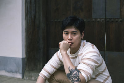 Portrait of young man sitting outdoors