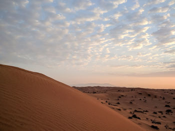 Scenic view of sand dunes against sky