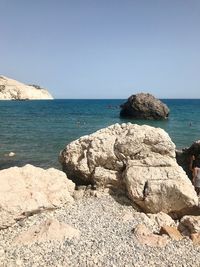 Scenic view of rocks on beach against clear sky