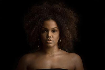 Portrait of a beautiful young woman over black background