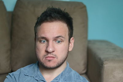 Portrait of young man relaxing on sofa at home