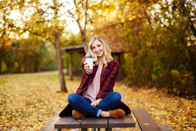 Portrait of smiling woman sitting in park