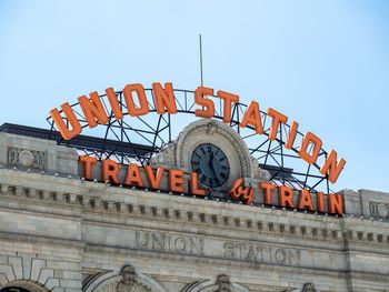 Low angle view of sign against sky in city