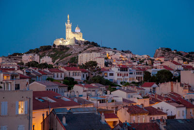 View of cityscape and notre-dame de la garde against clear blue sky