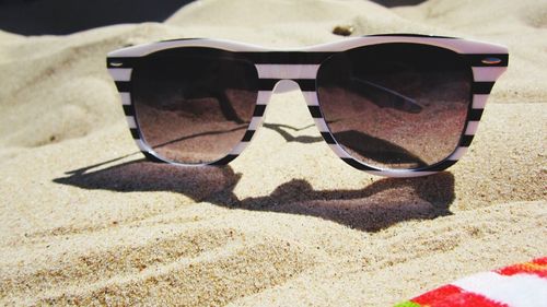 Close-up of sunglasses on beach