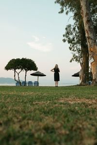 Rear view of woman on field against sky