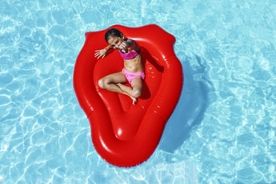 High angle view of young woman lying on swimming pool