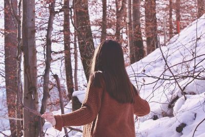 Rear view of woman in snow covered forest