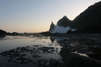 One big wave against solid rock with reflecting plateau in front at watu lumbung, indonesia