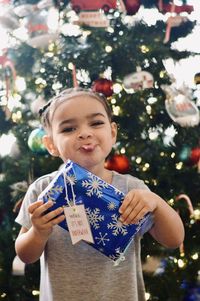 Portrait of boy holding christmas tree