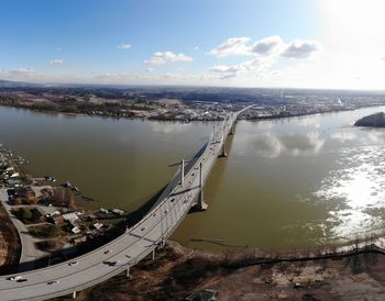 High angle view of city by sea against sky