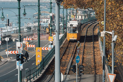 Yellow tram on tracks by danube river in budapest, hungary