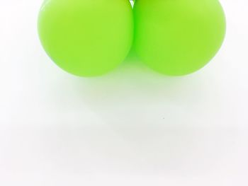 Close-up of green balloons against white background