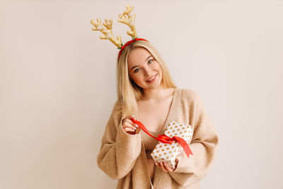 Portrait of smiling young woman against white background