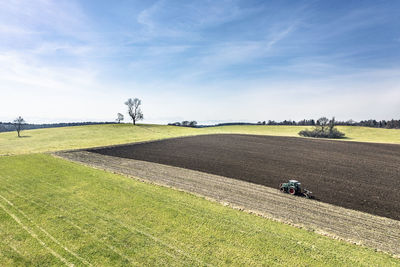 Aerial view of tractor plowing field in spring