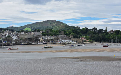 Scenic view of beach by buildings against sky