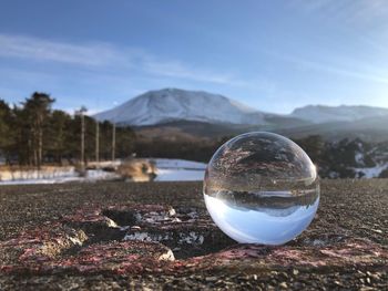 Crystal ball on landscape against sky