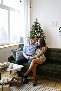 A young man and a woman in love are preparing together and celebrating new year and christmas home