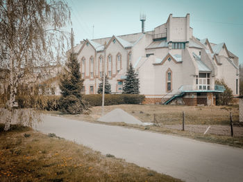 Houses by road in town against sky