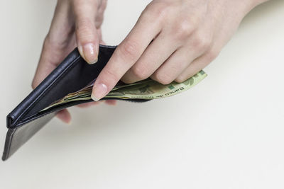Midsection of person holding paper against white background