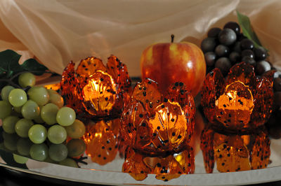 High angle view of fruits and tea light candles in container