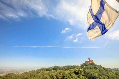 Low angle view of flag on building against sky