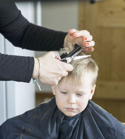 Boy getting haircut in barber shop