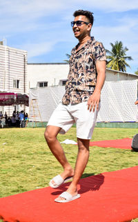 Full length of young man standing against building