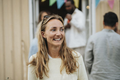 Happy young woman looking away during dinner party at cafe