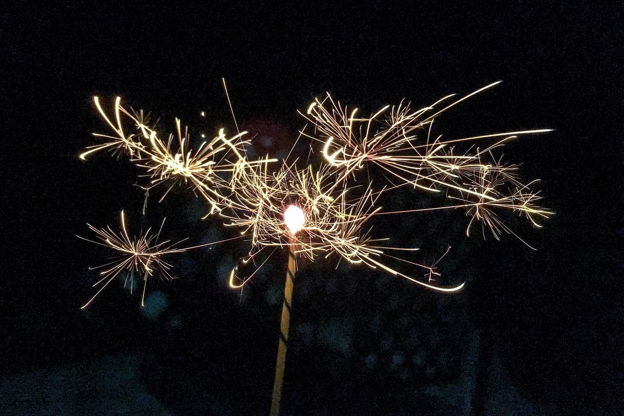 LOW ANGLE VIEW OF FIREWORKS EXPLODING IN NIGHT