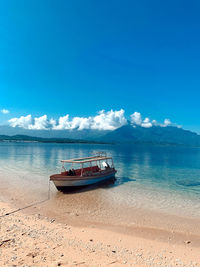 Boat moored on sea against sky