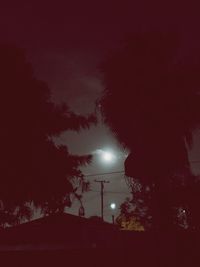 Low angle view of silhouette trees against sky at night