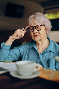 Thoughtful senior businesswoman working in cafe