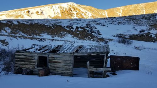 Built structure on snow covered mountain against sky