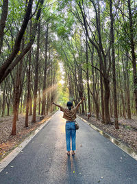 Rear view of boy running in forest