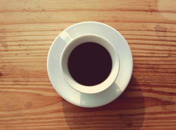 Directly above shot of coffee cup on wooden table