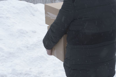 Rear view of woman standing in snow